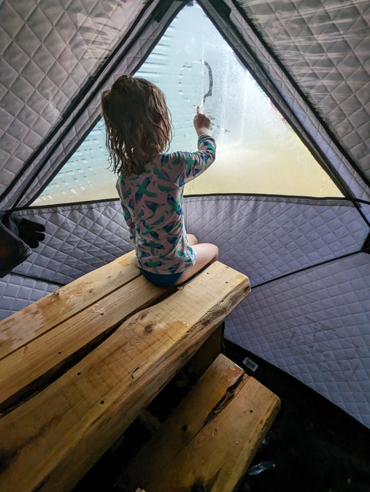 Drawing a heart a window in a steamy portable Ox Sweat sauna tent